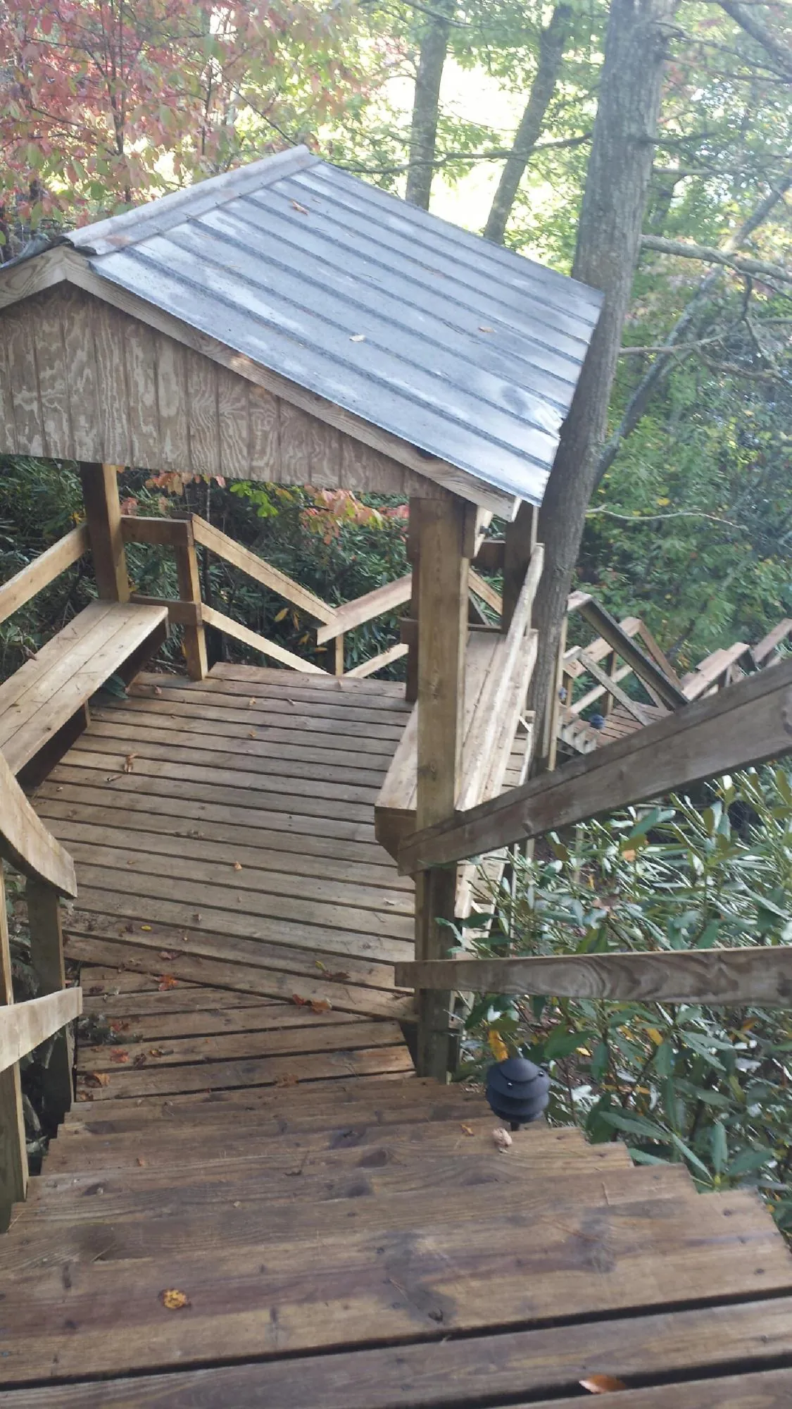 Metal roofed shelter over wooden steps on a wooded walkway — Skylight Repair & Installation work by our crew in Kamiah