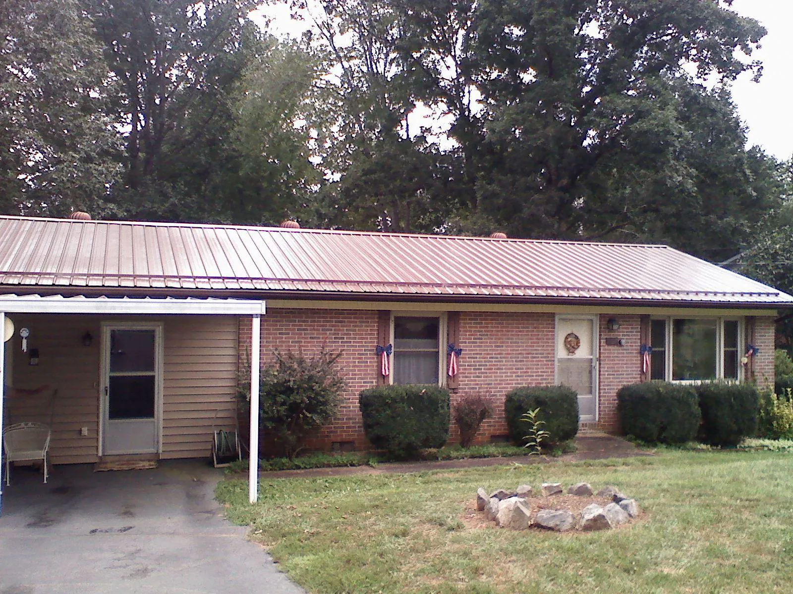 Bronze metal roof and carport on a brick ranch home — Roof Repair work by our crew in Kamiah